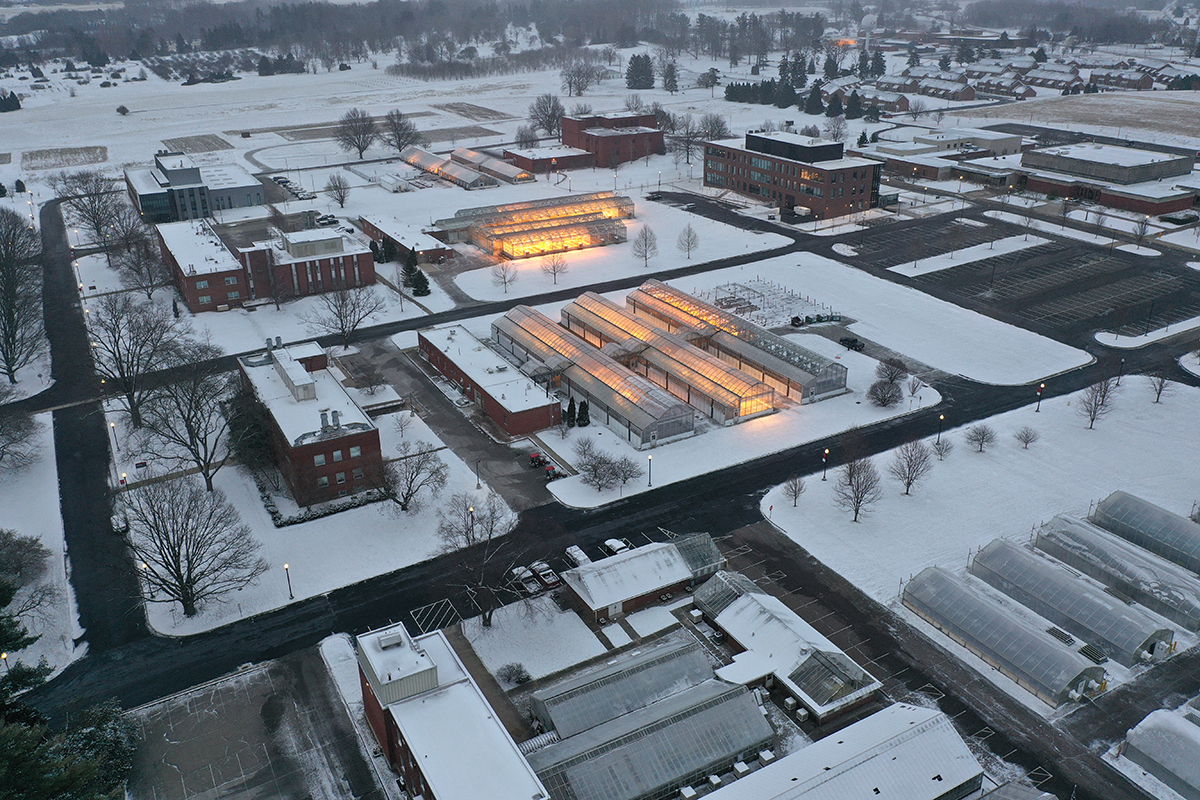 Snowy Wooster campus with greenhouses