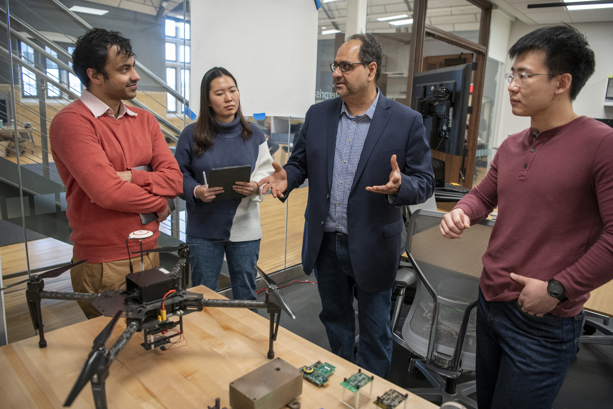 Faculty member discussing electronic engineering with students