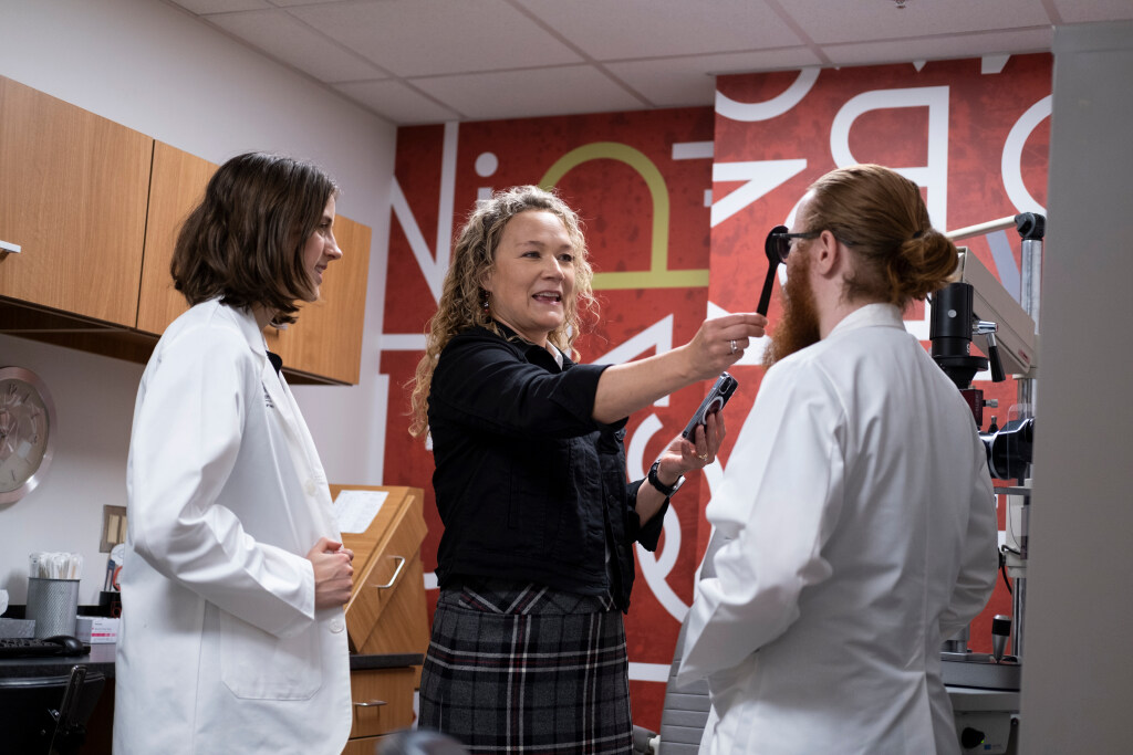 Optometrist faculty demonstrates for two students.