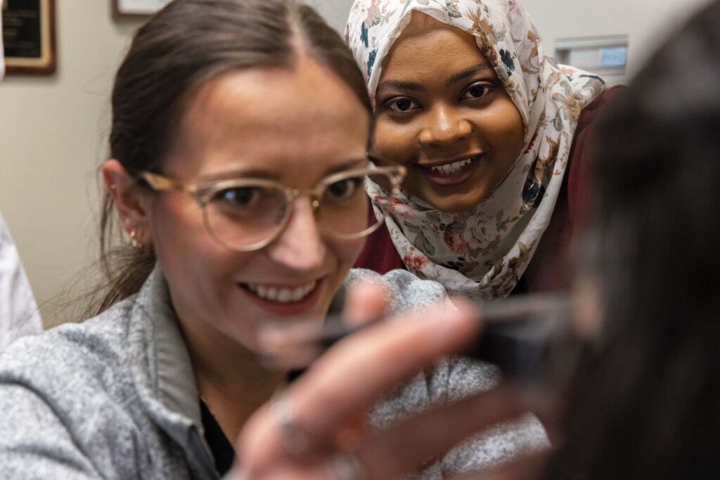 Two students examine something closely.