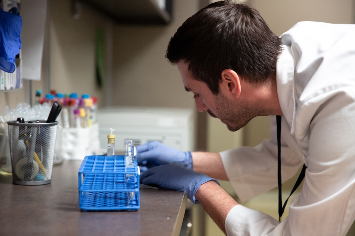 A pharmacy student takes notes in a lab.