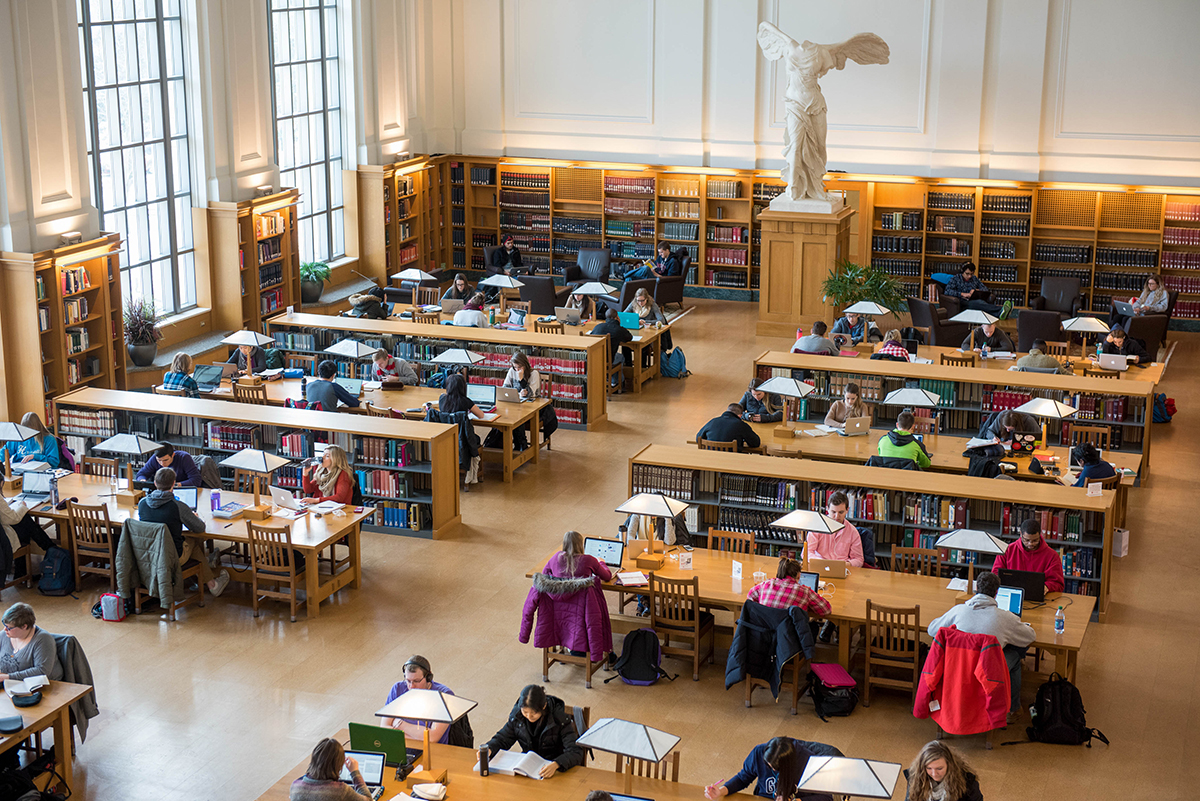 Busy library study hall filled with students reading