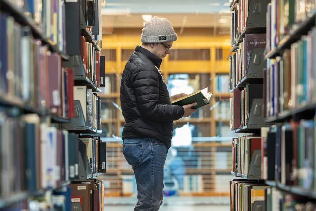 Student looks through books for the right information